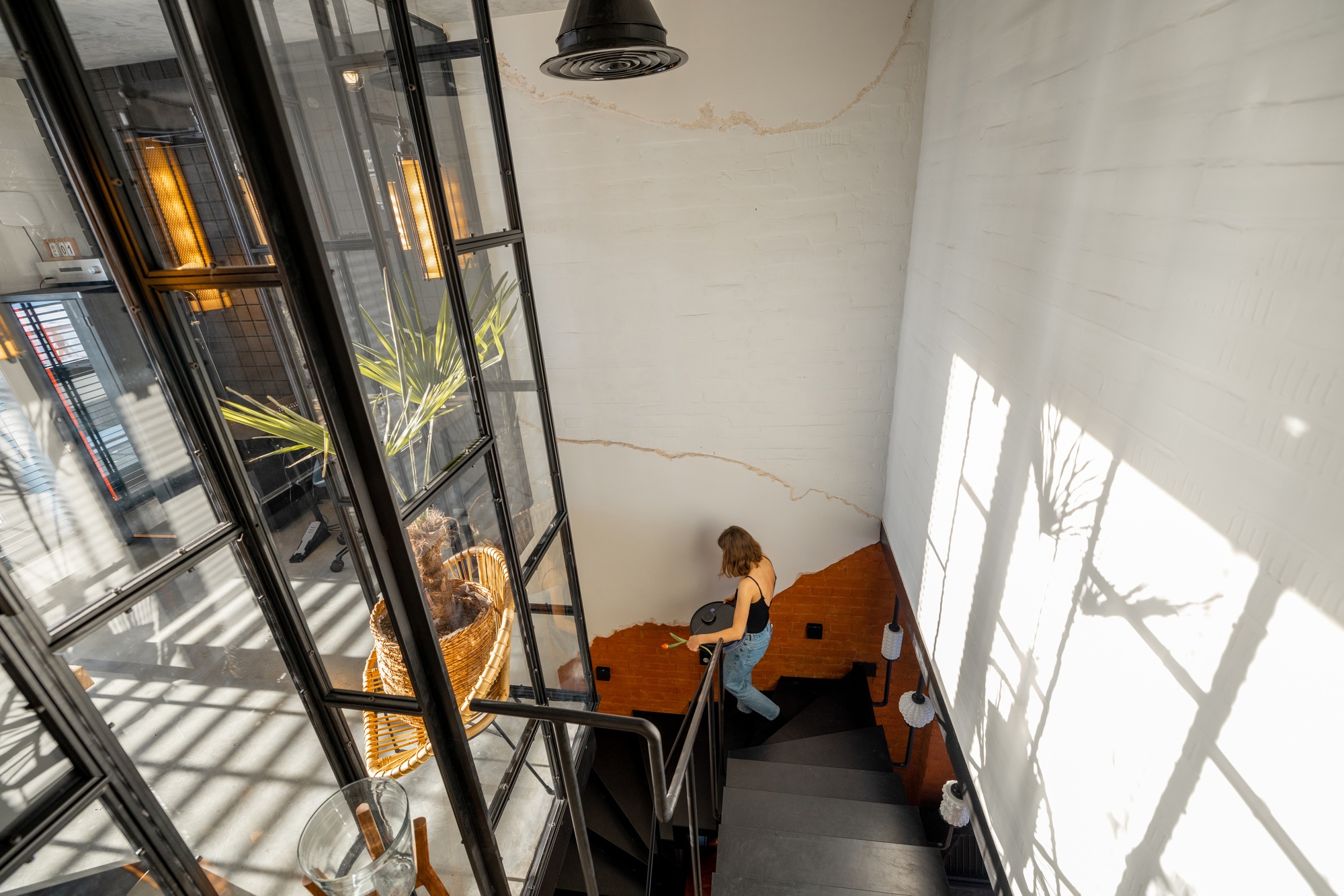 House hallway with metal stairs and glass partition in loft style