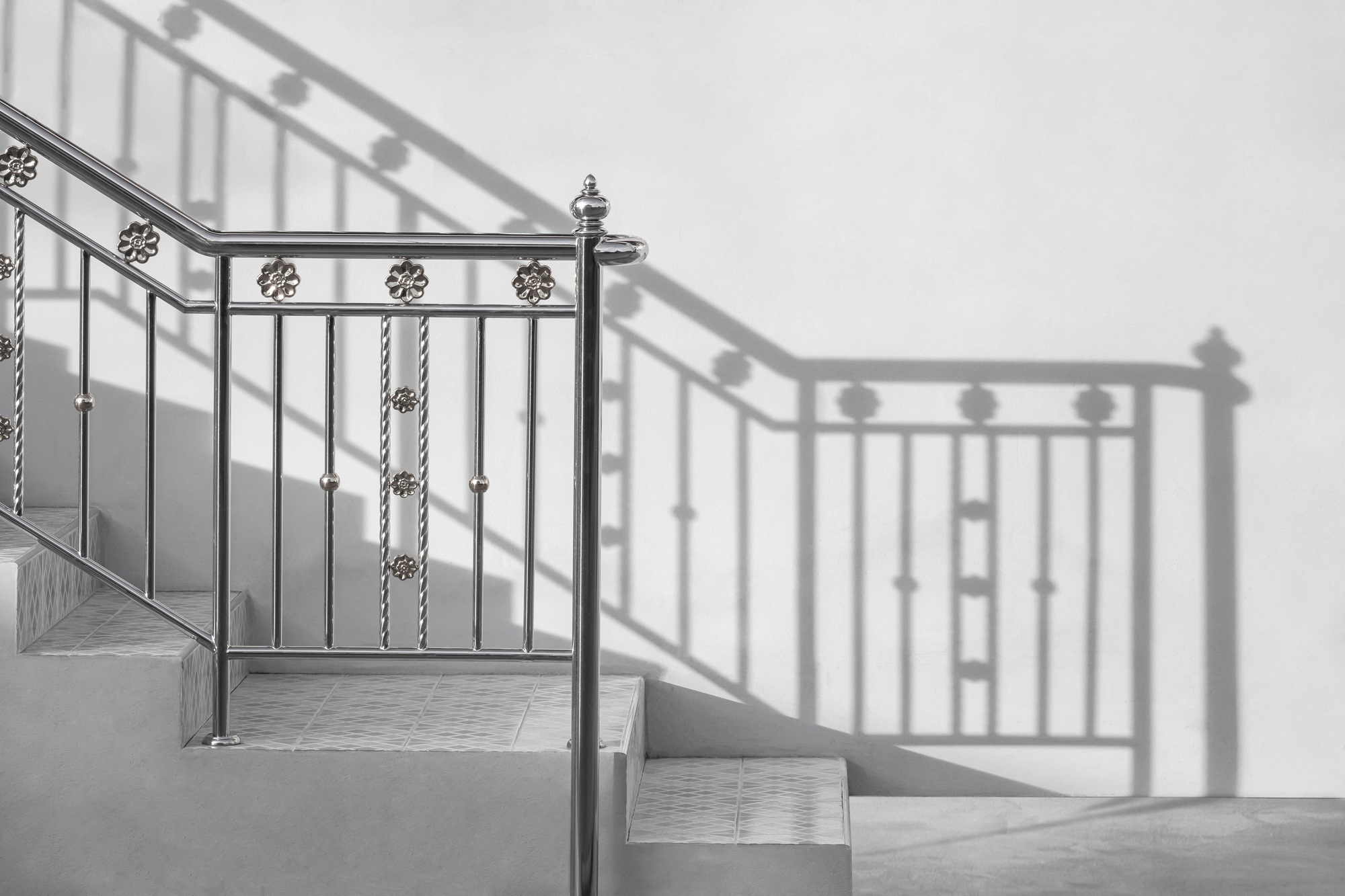 Stainless steel handrail of vintage outdoor staircase with sunlight and shadow on cement wall